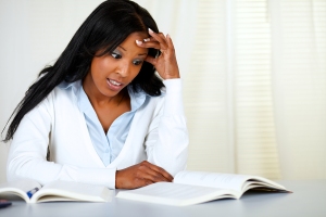 Stressed young black woman studying